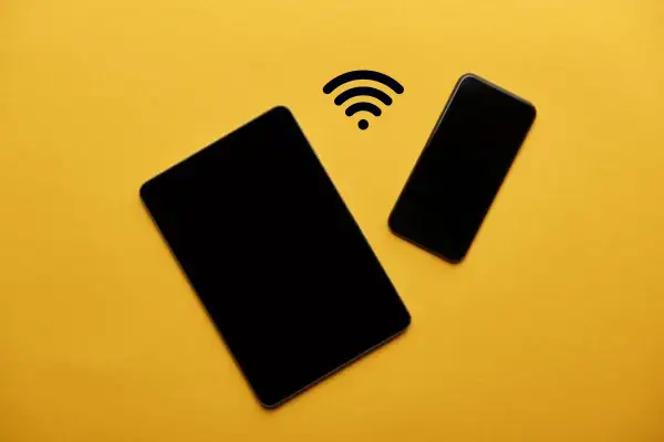 Dos dispositivos Android, una tablet y un teléfono, conectados por un símbolo de Wi-Fi, listos para compartir datos.